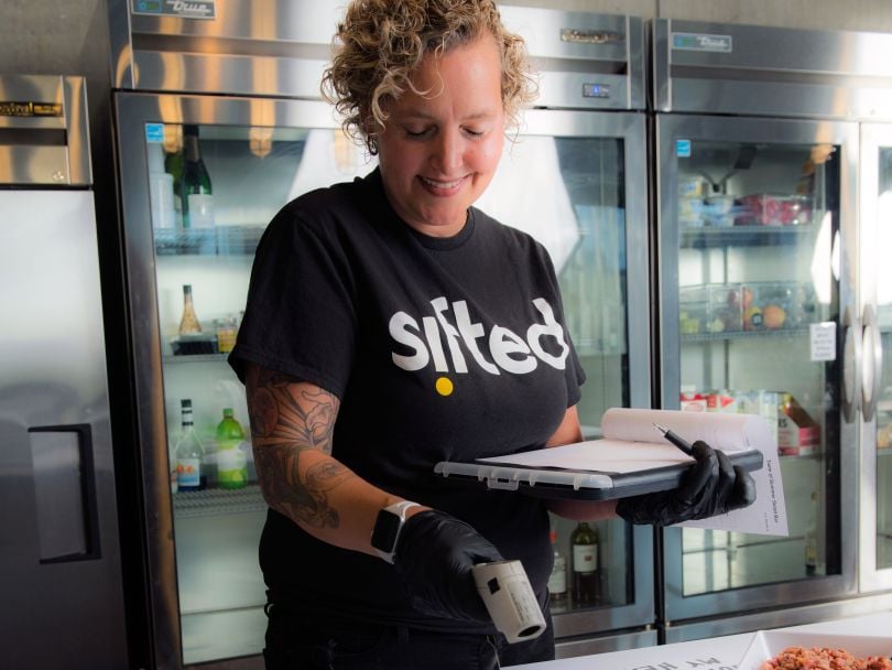 A Sifted employee checks food being prepared for a Sifted-catered meal